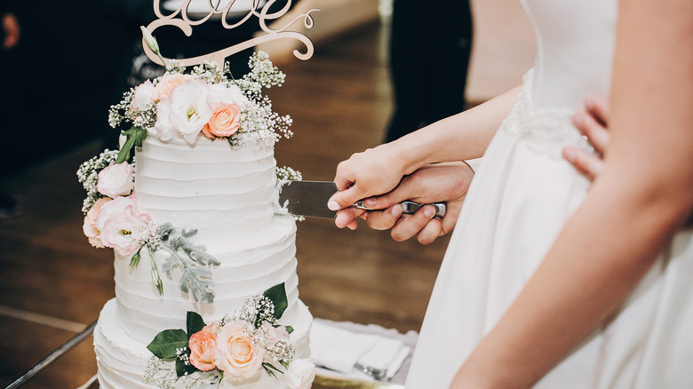bride cutting a wedding cake