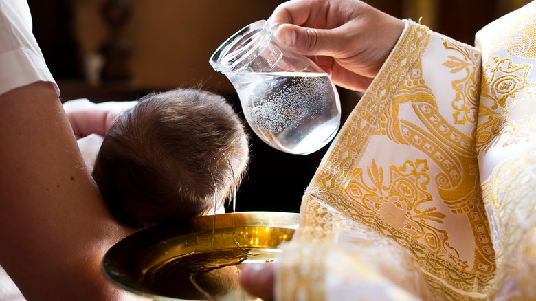 catholic priest baptizes an infant