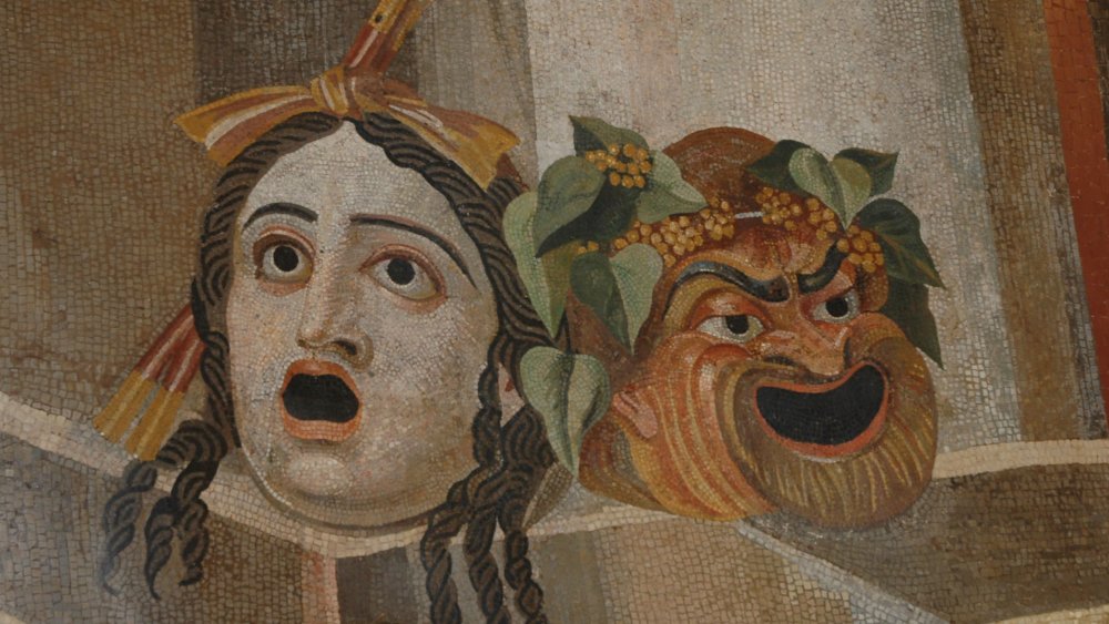 A photograph of ancient tiles depicting a laughing and fearful face.