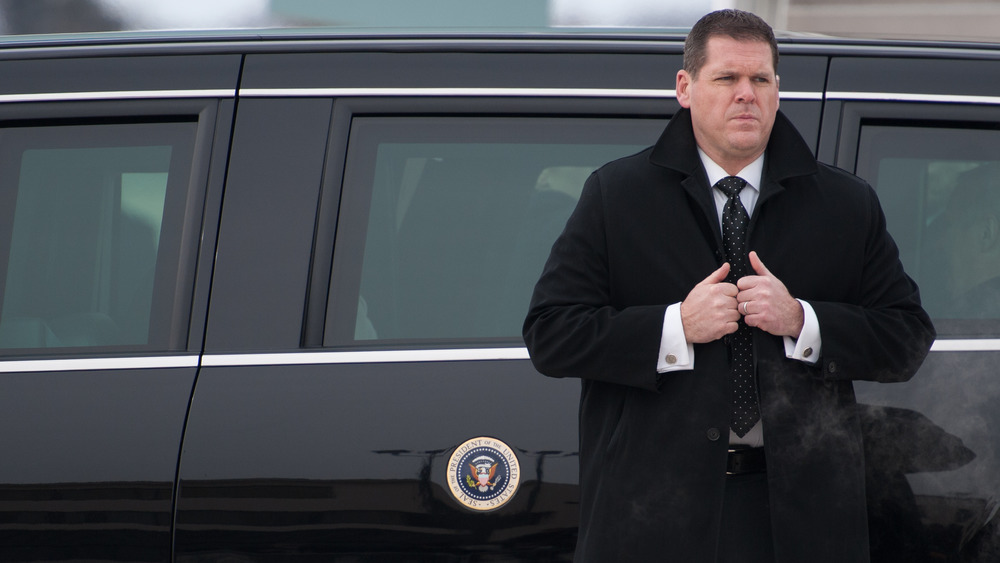 Secret Service agent standing outside presidential limousine 