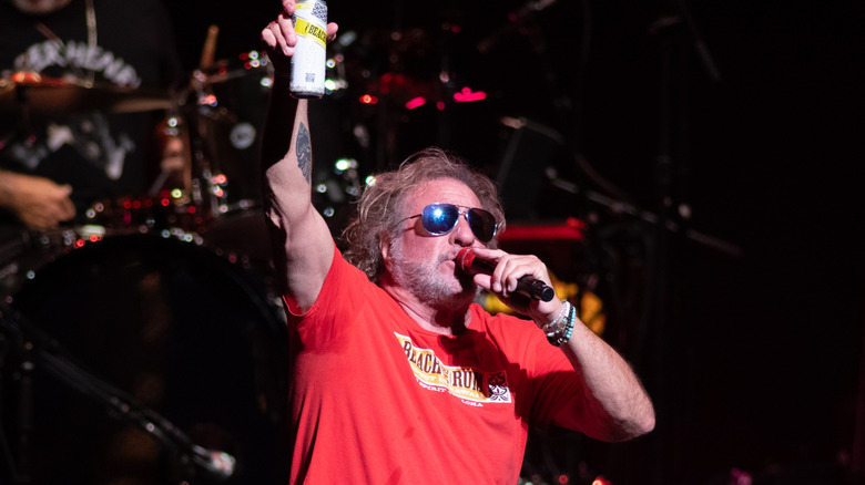 Sammy Hagar holding up a can singing on stage