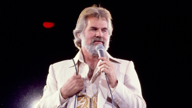 Kenny Rogers wincing with emotion while singing onstage in the early 1980s