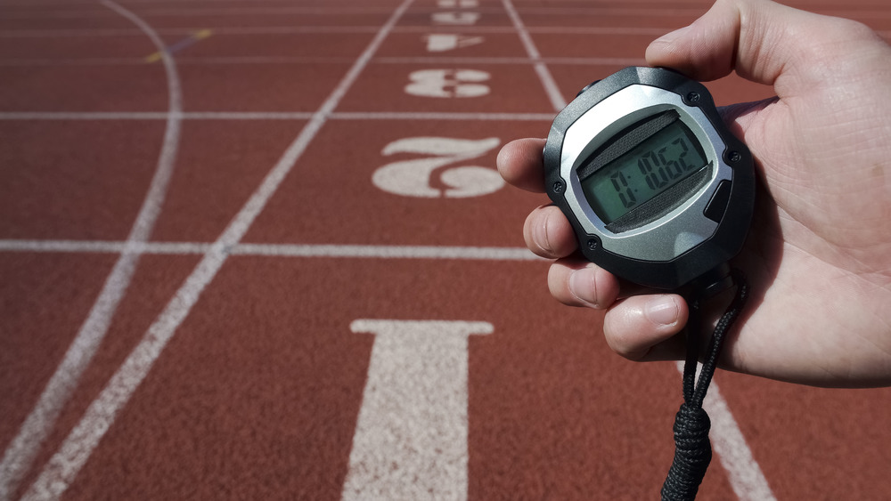 hand holding stopwatch on track