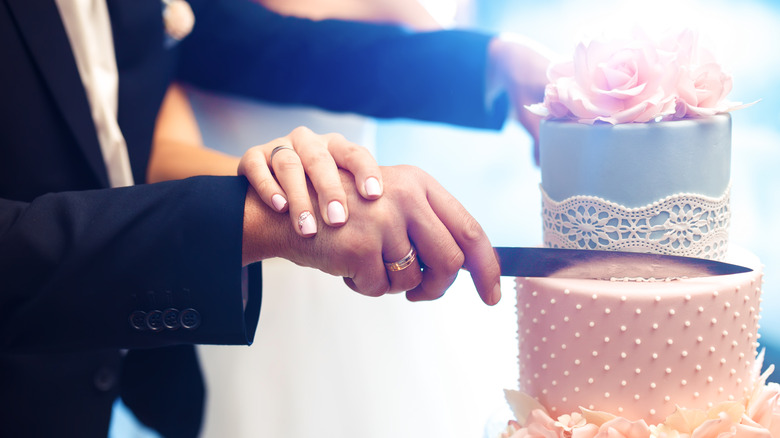 Couple cutting wedding cake