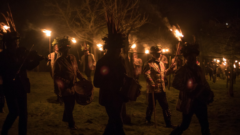 A party of wassailers with torches