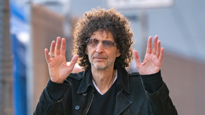 Howard Stern walking with hands raised