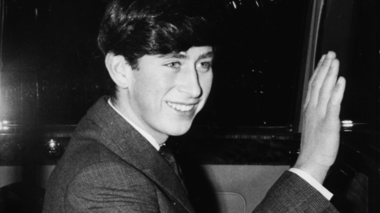 Prince Charles waves from inside a car