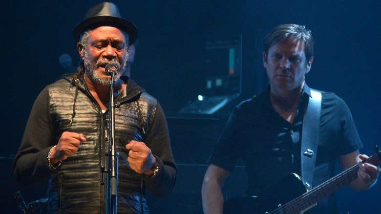 Massive Attack performing mic guitar on stage