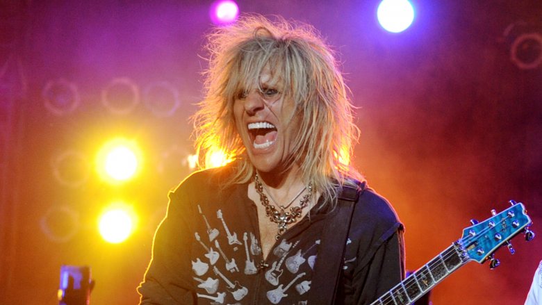 cc deville with long hair singing with guitar on stage