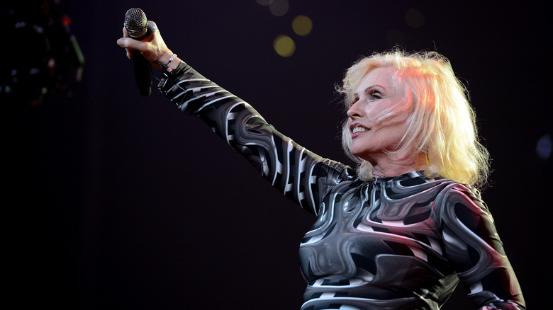Debbie Harry performing on stage arm raised