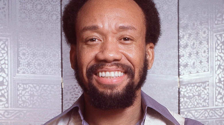 Maurice White smiling beard white panel screen background