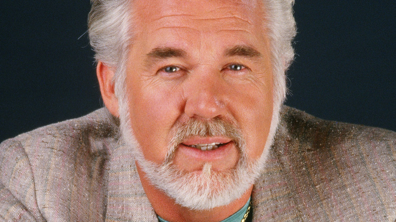 kenny rogers posing with an album