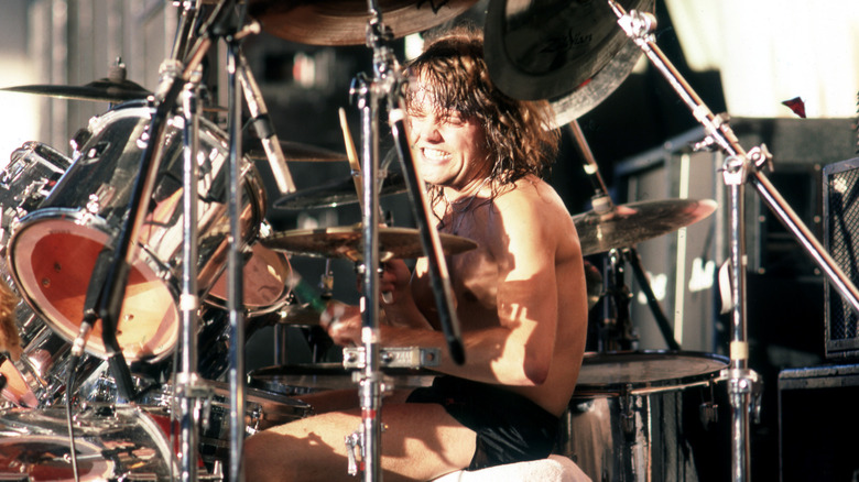 Lars Ulrich smiling, performs onstage