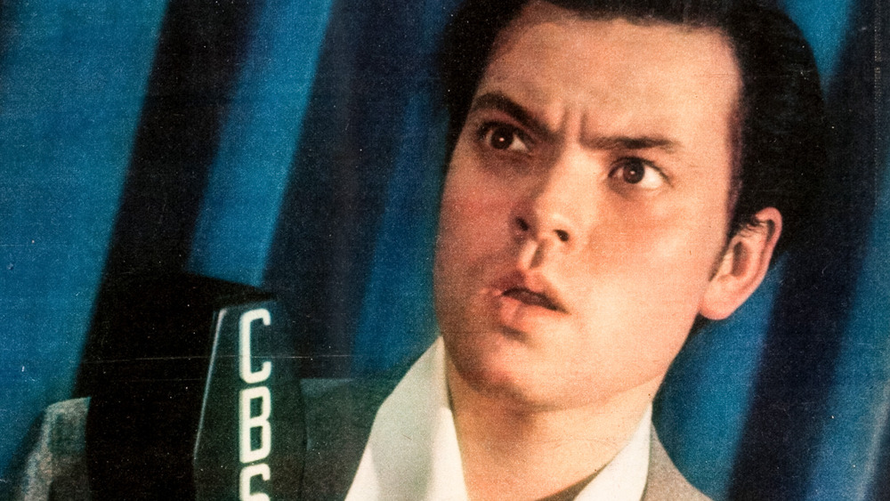 Color portrait photograph of Orson Welles on the cover of the New York Sunday News, recreating the CBS Radio studio in the newspaper's photographic studio in 1938