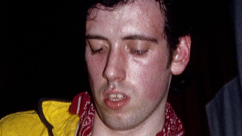Mick Jones playing guitar looking down