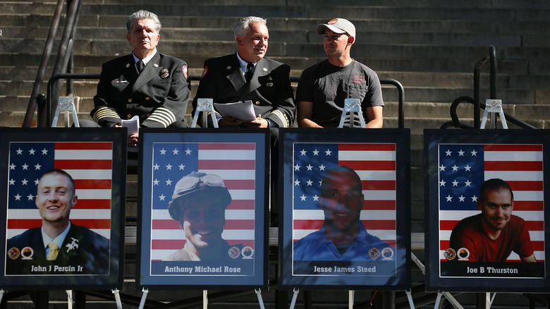 Three men behind photographs of Hotshot firefighters