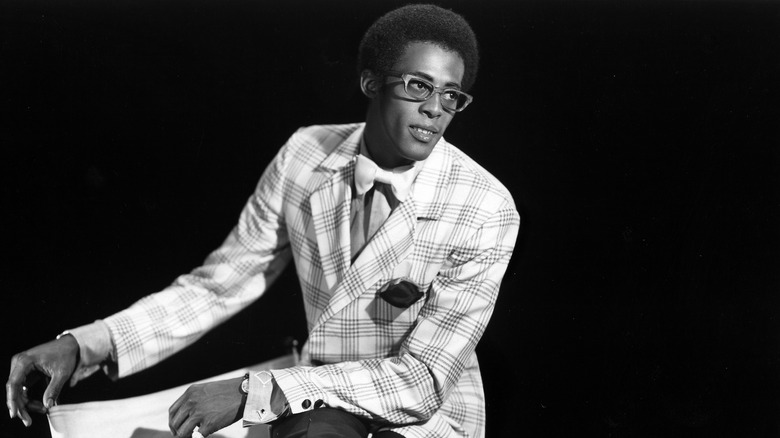 David Ruffin white suit glasses sat smiling