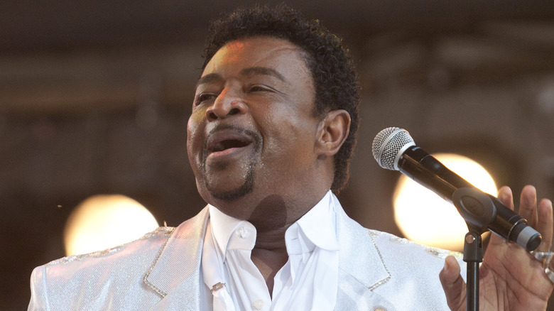Dennis Edwards white suit singing on stage