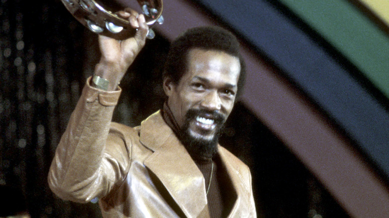 Eddie Kendricks holding up tambourine smiling