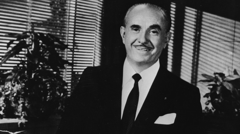 Jack Warner, standing and smiling