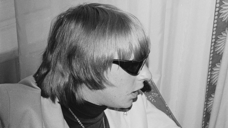 Keith Relf sitting backstage wearing sunglasses