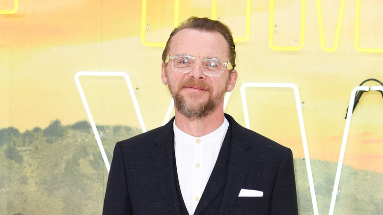 Simon Pegg smiling yellow background