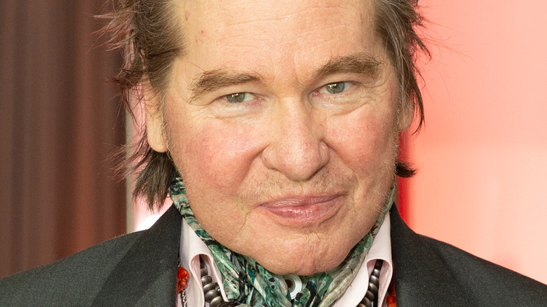 Val Kilmer with a scarf and necklace