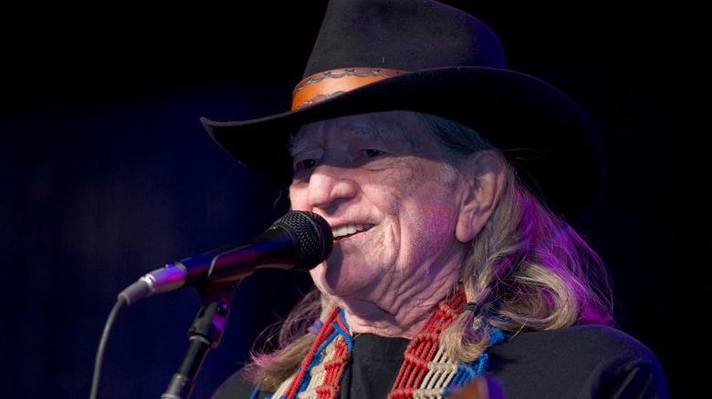Willie Nelson smiling at microphone