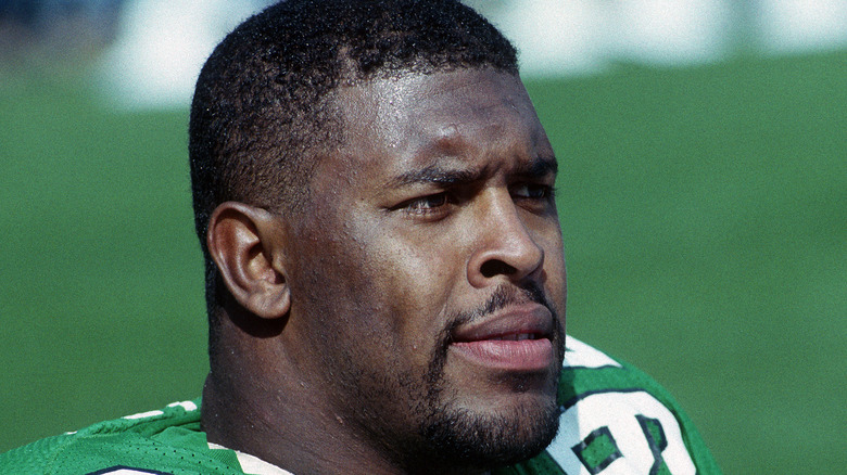 Reggie White looks at football field