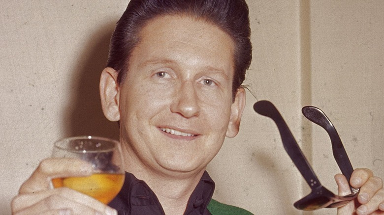 Roy Orbison holding sunglasses and a drink