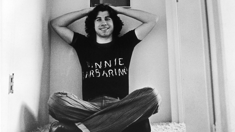 Young John Travolta sitting cross-legged