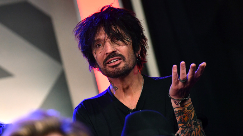 Tommy Lee holding up hand
