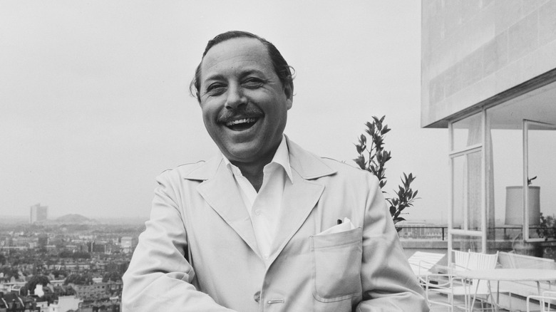 Tennessee Williams outside a modern house with a gorgeous view