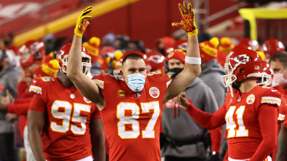 Travis Kelce arms raised red uniform mask