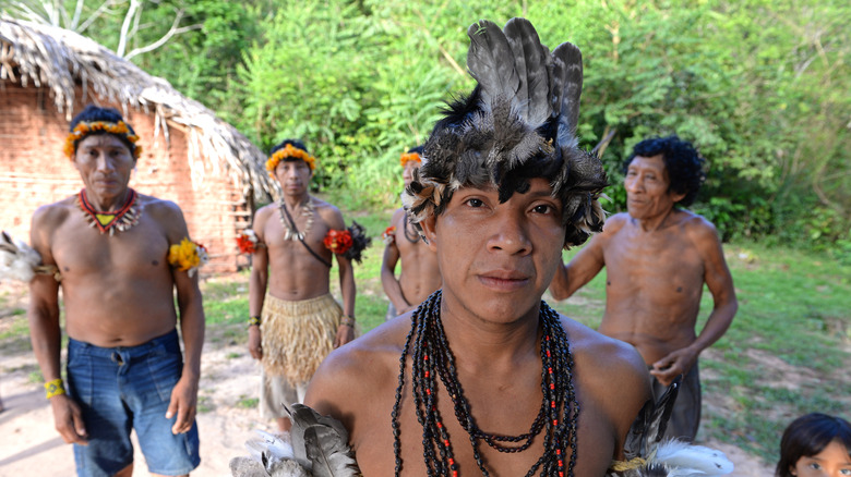 A group of Awá standing in traditional dress in village