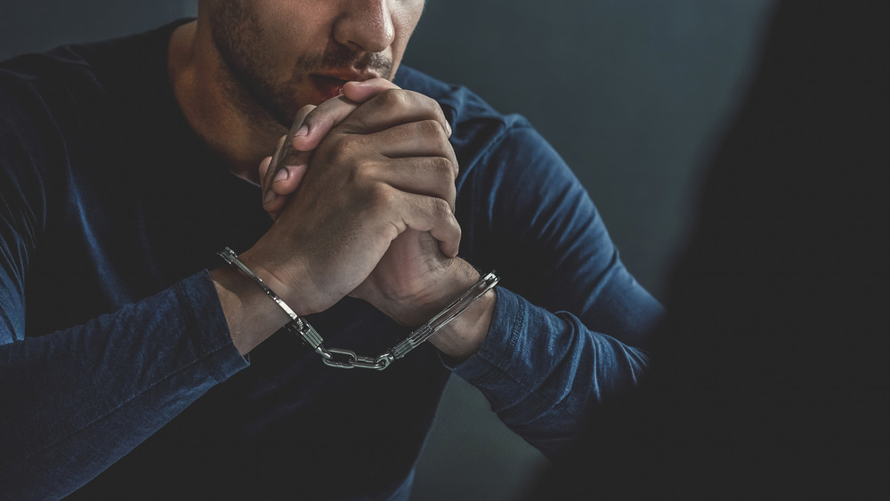 A man in cuffs speaking with someone