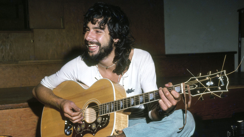 Cat Stevens happily playing guitar