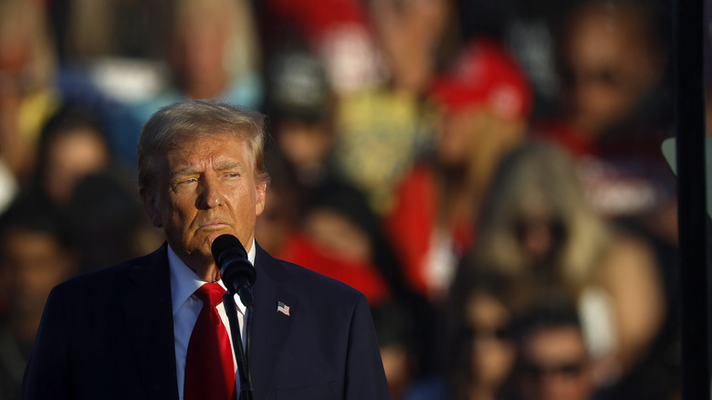 Donald Trump on stage frowning with microphone