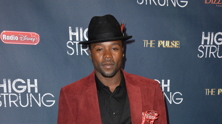 Joshua Allen in feathered hat on red carpet