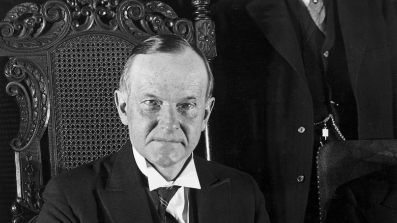 Calvin Coolidge seated at his desk