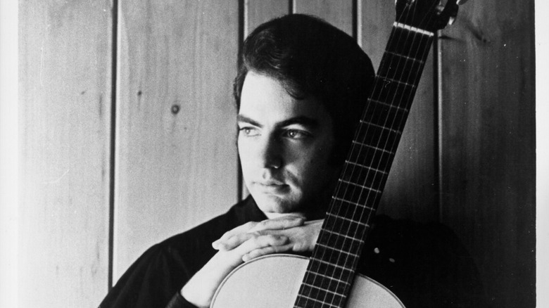 A young Neil Diamond with an acoustic guitar