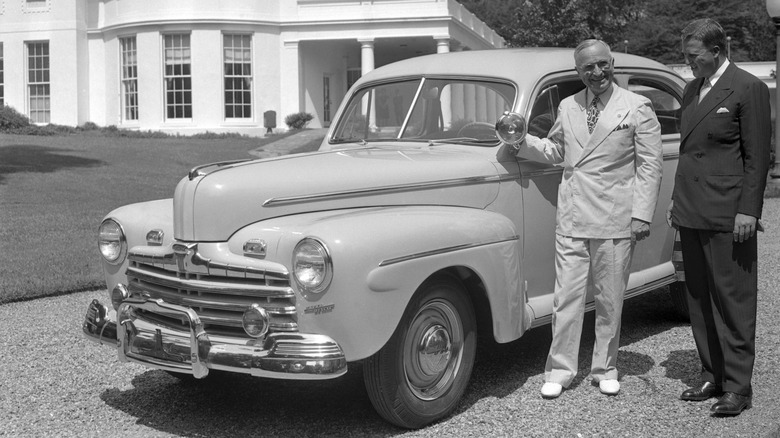 Harry Truman being presented with a car by Henry Ford Jr. in front of the White House