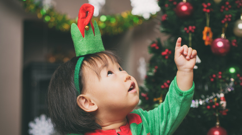 little girl pointing at Christmas tree