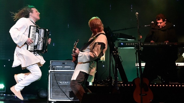 Weird Al Yankovic performs on stage with his band.