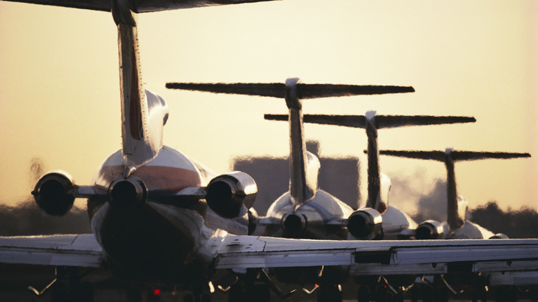 A row of grounded planes at sunset