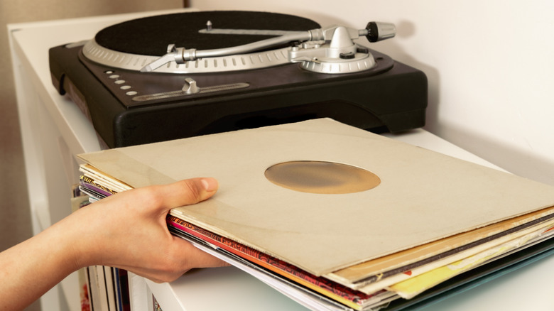 Hand holding a small stack of vinyl records