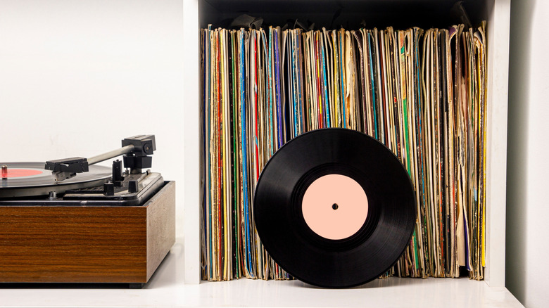 A vinyl record collection stacked vertically with record player