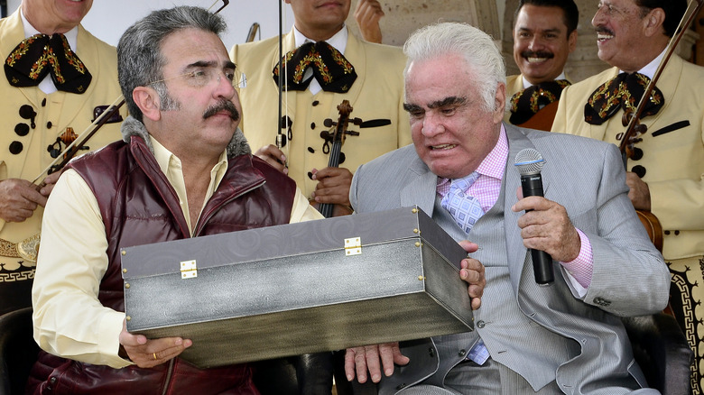 Vicente Fernandez sitting with his son, Fernandez Jr.
