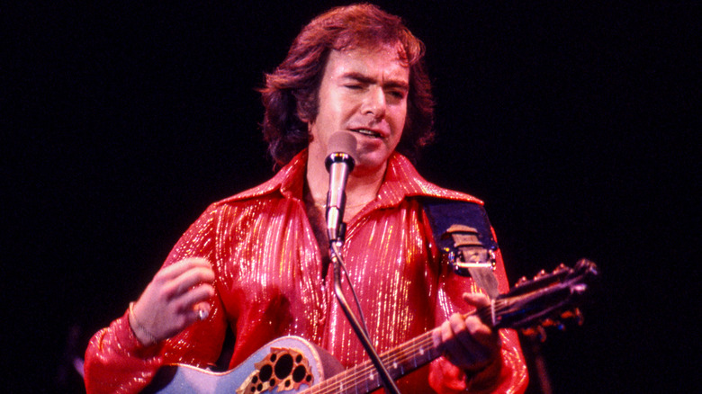Neil Diamond in red shirt playing guitar in the '70s