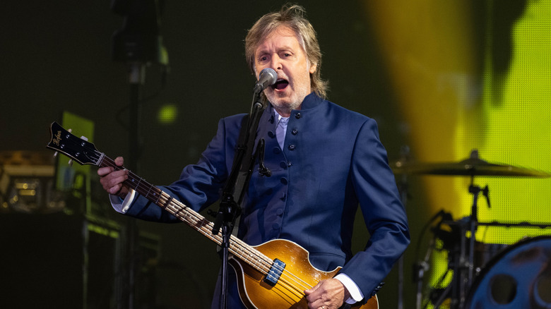 Paul McCartney performing in blue suit on stage